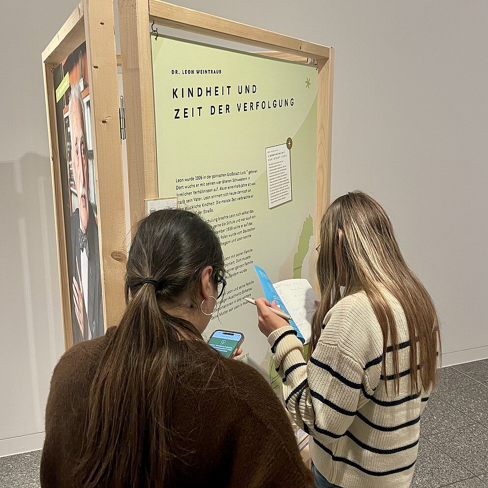 Zwei Personen stehen vor einem Plakat