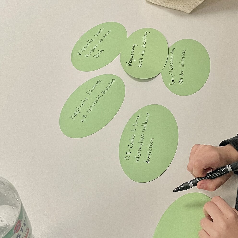 Grüne runde Karten mit Text liegen auf einem Tisch